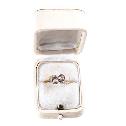 A two stone diamond crossover ring in yellow and white gold, in a ring box