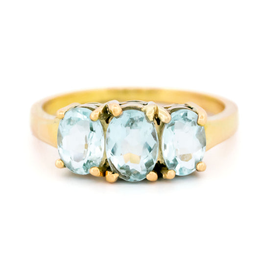 A three stone oval aquamarine ring in yellow gold