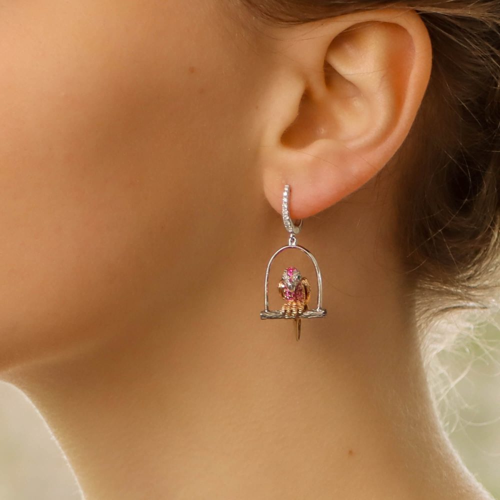 Tsavorite Garnet and Fancy Colour Sapphire Parrot Earrings, each parrot is perched on a white gold swing roost and set with blue, pink, orange and yellow sapphires, rubies, tsavorite garnets and diamonds