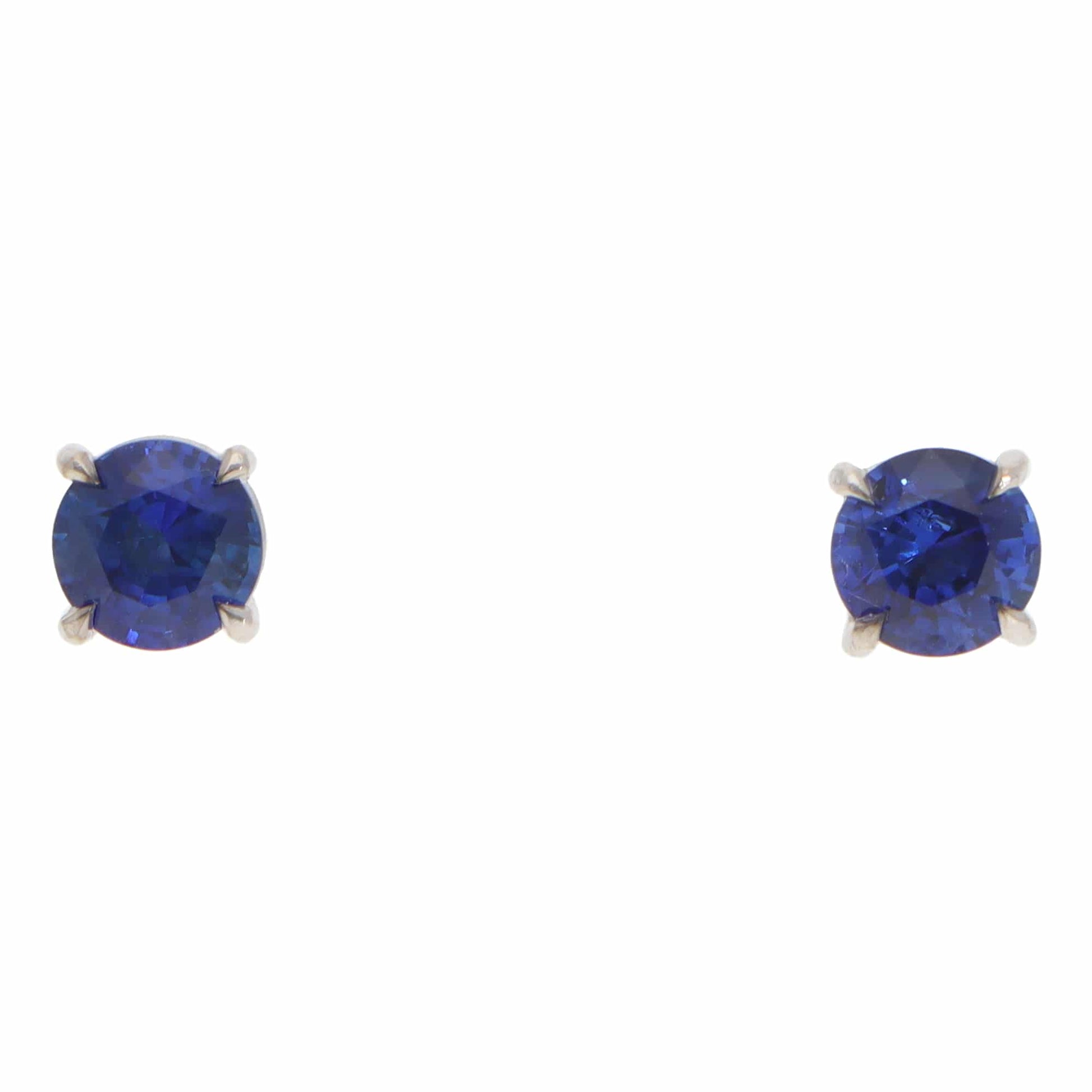 A pair of blue sapphire single stone stud earrings in white gold, on a white background