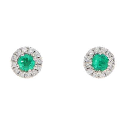 A pair of emerald and diamond round cluster stud earrings in white gold, on a white background
