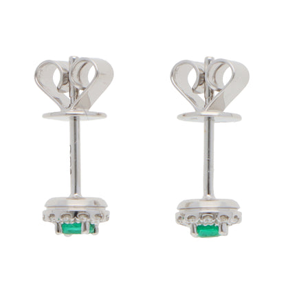A pair of emerald and diamond round cluster stud earrings in white gold, on a white background