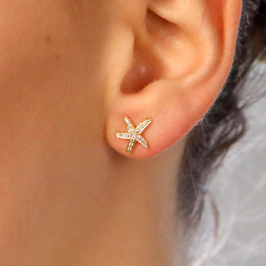 Modern diamond starfish stud earrings set in yellow gold.