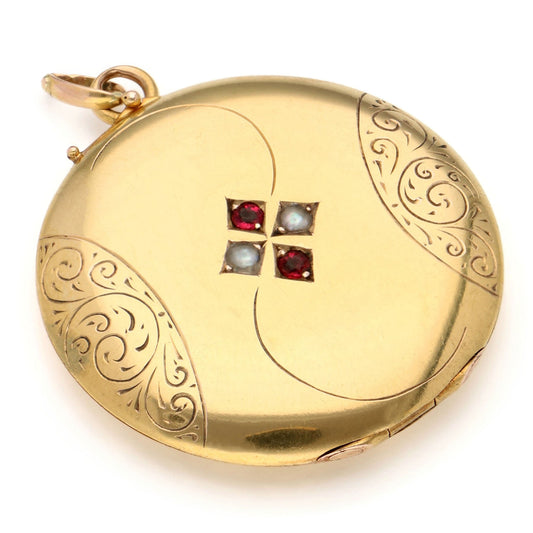 A round yellow gold locket pendant with faux pearls and red paste