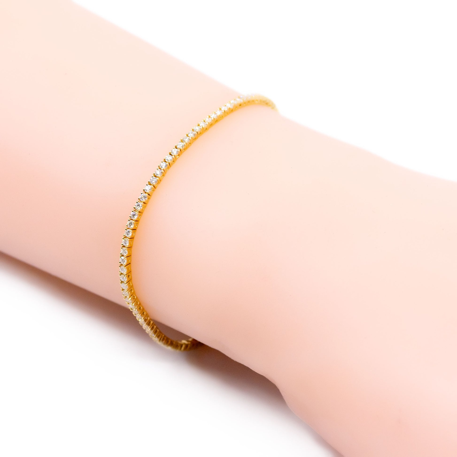 A yellow gold diamond line bracelet, modelled on a wrist