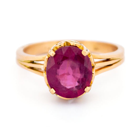 An oval ruby solitaire ring in yellow gold