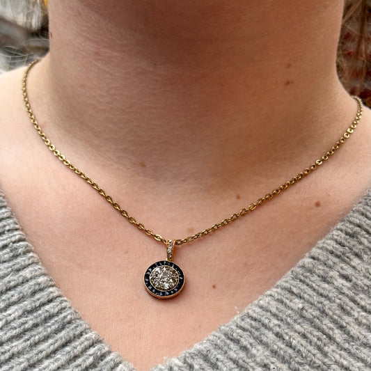 A circular sapphire and diamond pendant in yellow gold, modelled with a gold chain