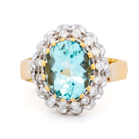 An aquamarine and diamond oval cluster ring in yellow and white gold
