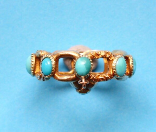 Antique Georgian Turquoise and Gold Ring; set with round cabochon cut turquoises from which suspends a small heart shaped locket. England, Circa 1840