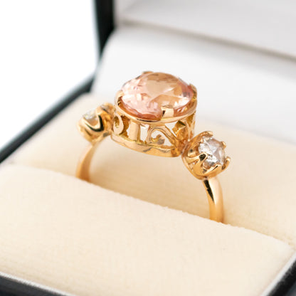 A three stone oval morganite and diamond ring in yellow gold, in a ring box