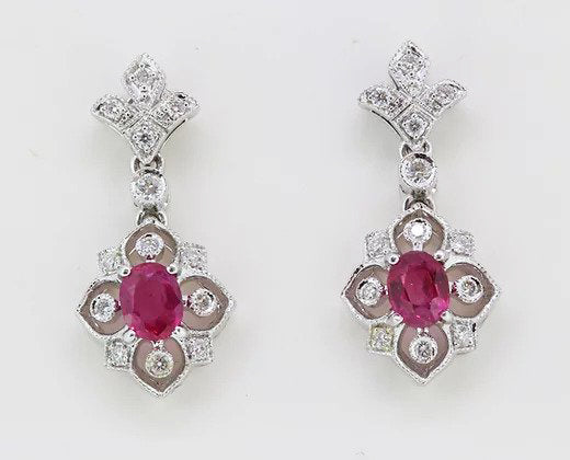 Pair of Decorative Ruby and Diamond Floral Drop Earrings; oval rubies surrounded with diamond-set geometric floral border, 18ct white gold.