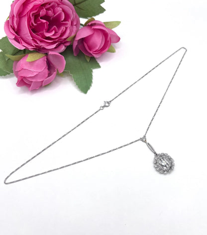A platinum floral wreath pendant with diamonds on a platinum chain