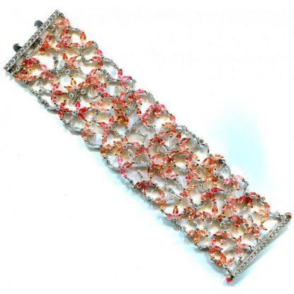 Padparadscha Sapphire, Diamond and Ruby Bracelet; set with 39.52cts pink, orange and red, marquise-cut padparadscha sapphires, decorated with 6.14cts round brilliant-cut diamonds. Accented with cabochon-cut ruby set terminals on the clasp. Mounted in platinum and 18ct yellow gold