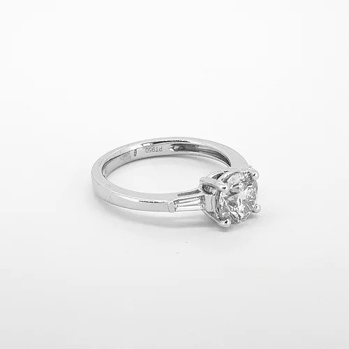 1.16ct Diamond Solitaire Engagement Ring with Baguette Diamond Shoulders; featuring a 1.16 carat round brilliant cut diamond, four-claw set in platinum, flanked by two tapered baguette diamonds on the shoulders