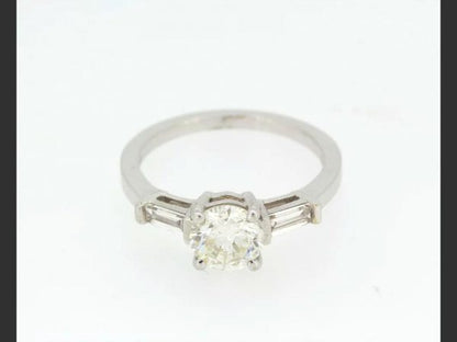 Solitaire Diamond Ring; central 1.23ct round cut diamond, flanked by baguette shoulders totaling 0.33ct, detailed 750, 18ct white gold