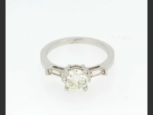 Solitaire Diamond Ring; central 1.23ct round cut diamond, flanked by baguette shoulders totaling 0.33ct, detailed 750, 18ct white gold
