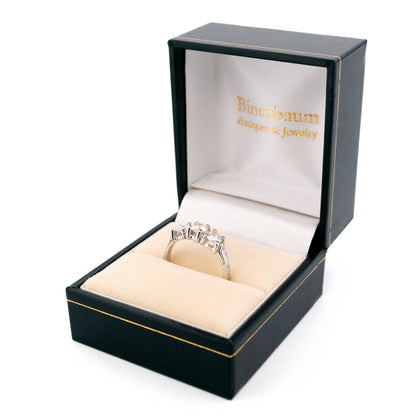 A three stone round diamond ring claw set in platinum, in a ring box