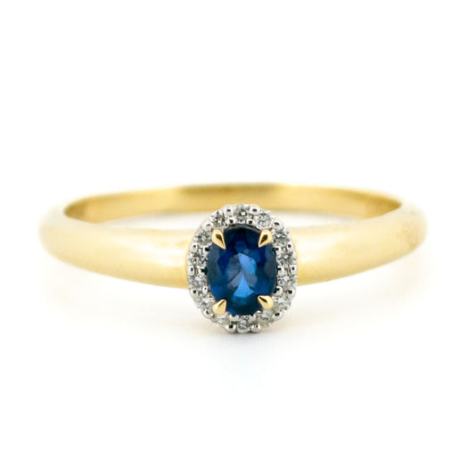 An oval sapphire and diamond cluster ring in yellow and white gold