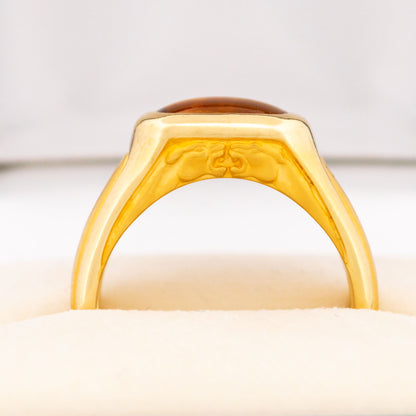 A yellow gold citrine ring, showing two panther heads, in a ring box