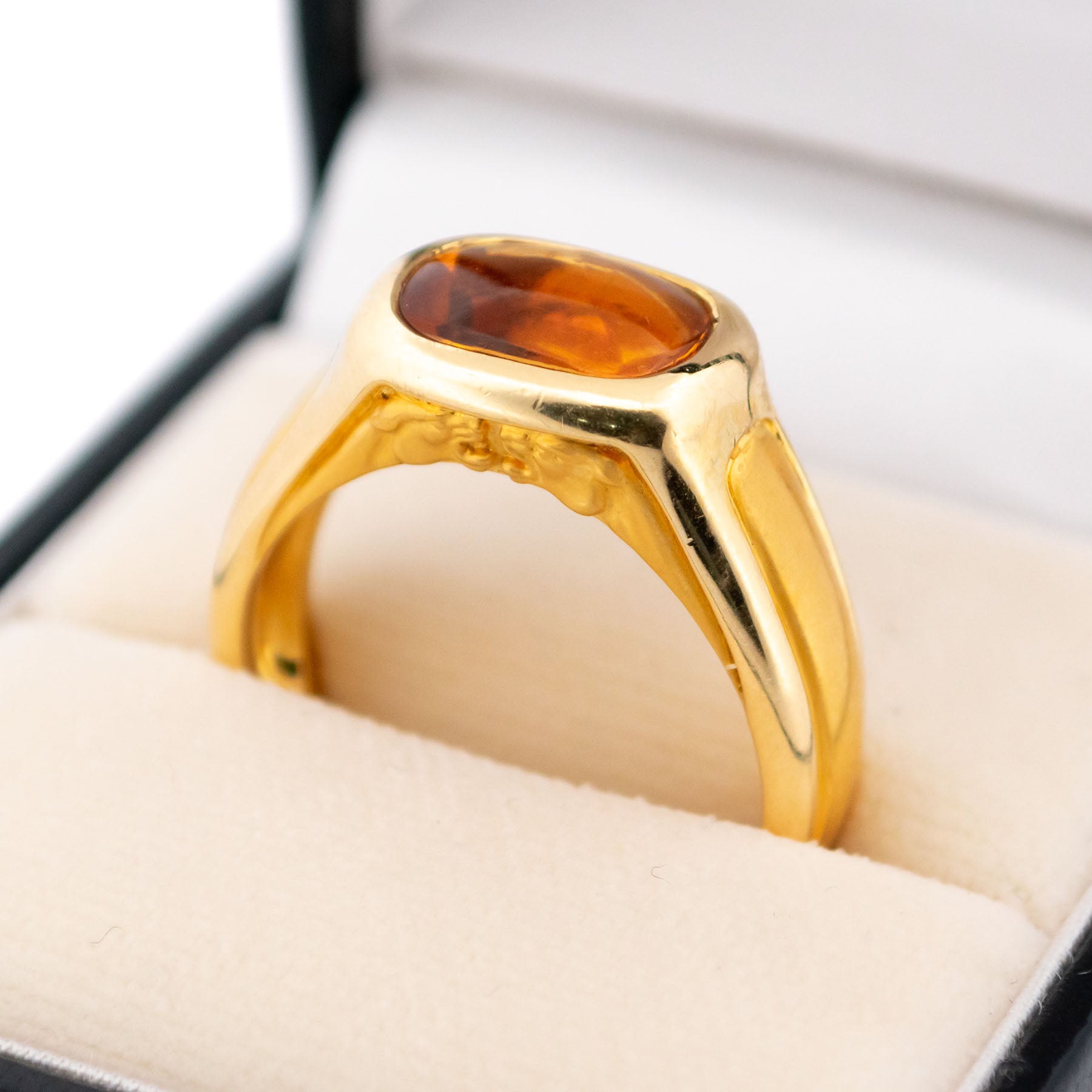 A yellow gold citrine ring, showing two panther heads, in a ring box