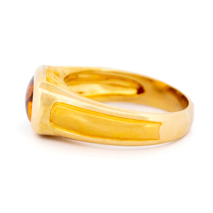 A yellow gold citrine ring, on a white background
