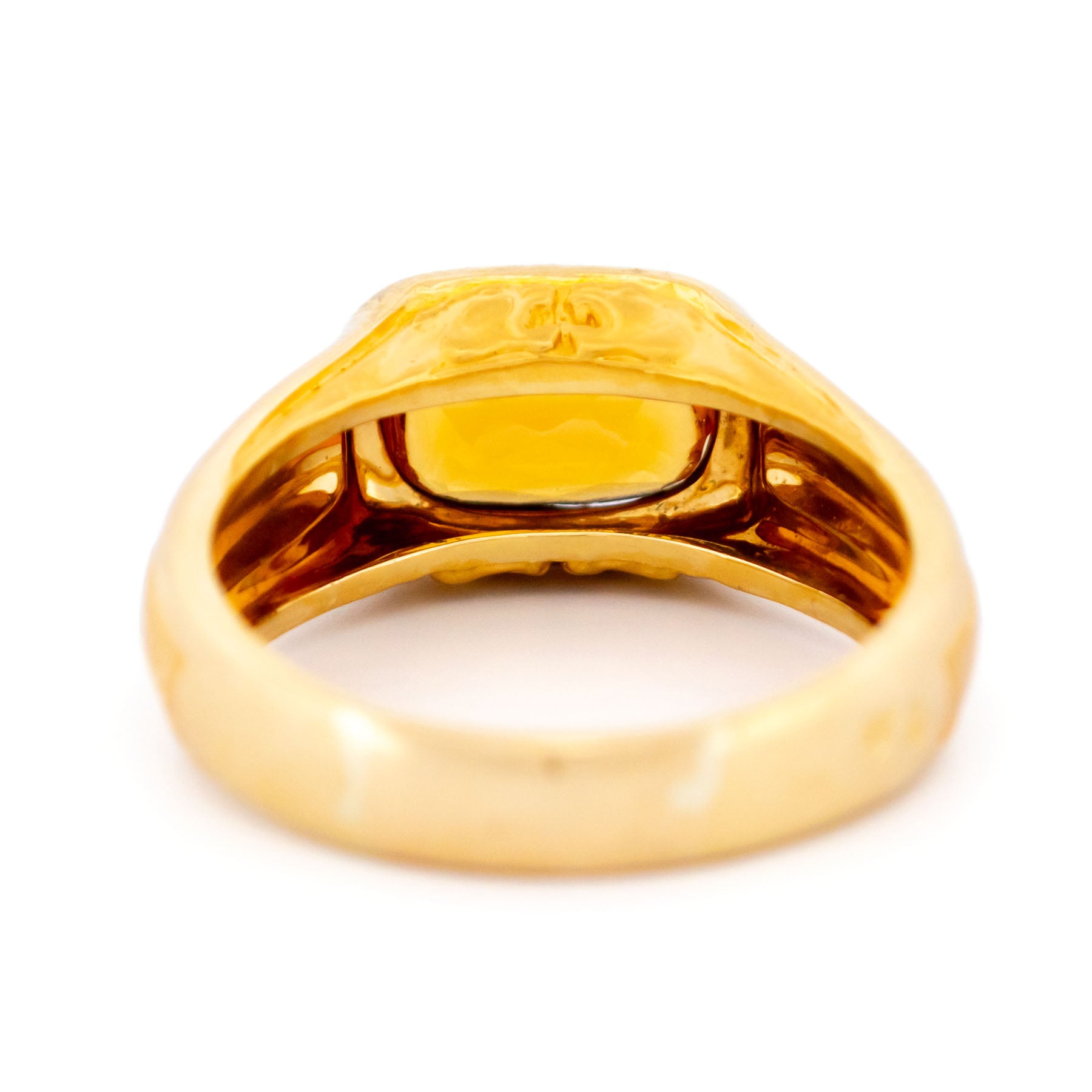 A yellow gold citrine ring, on a white background