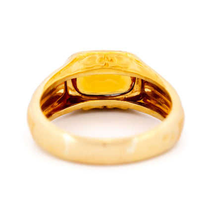 A yellow gold citrine ring, on a white background