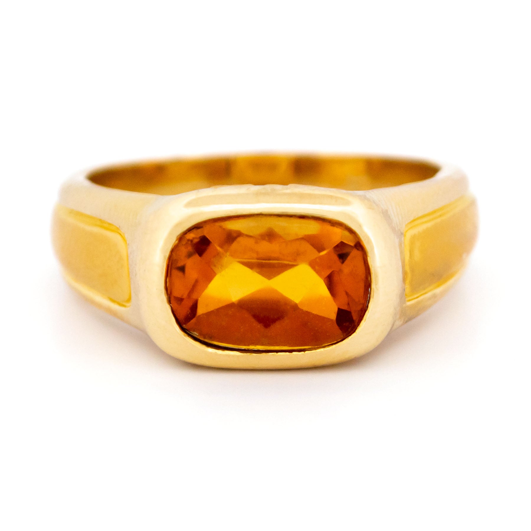A yellow gold citrine ring, on a white background