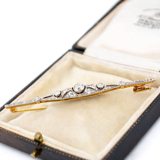 A diamond bar brooch in gold and platinum, in an antique box