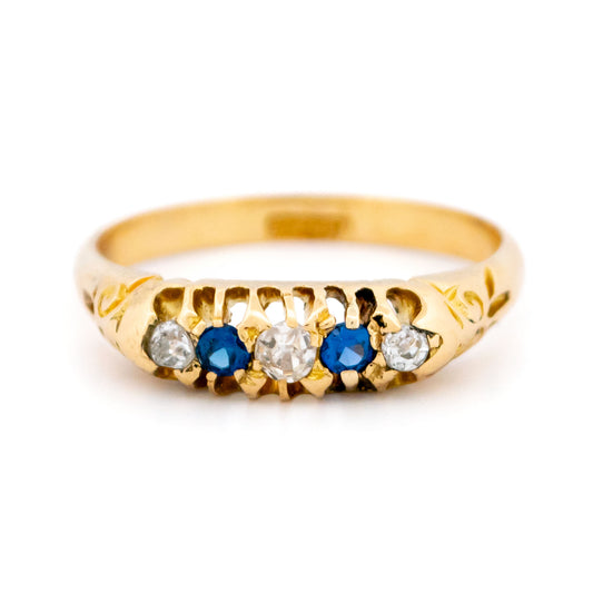 A sapphire and diamond five stone ring in yellow gold, on a white background