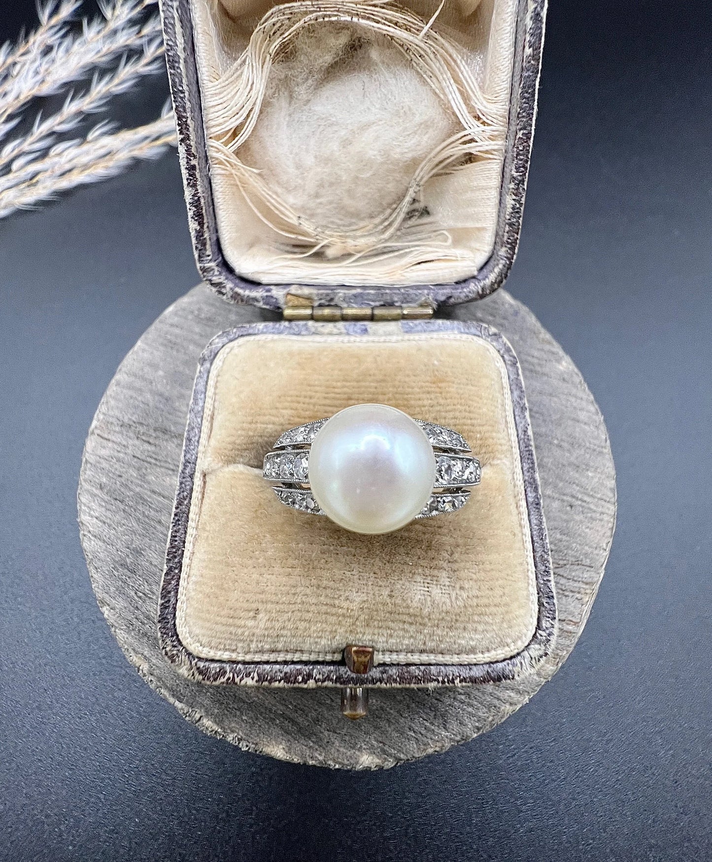 A pearl and diamond ring in platinum, in an antique ring box