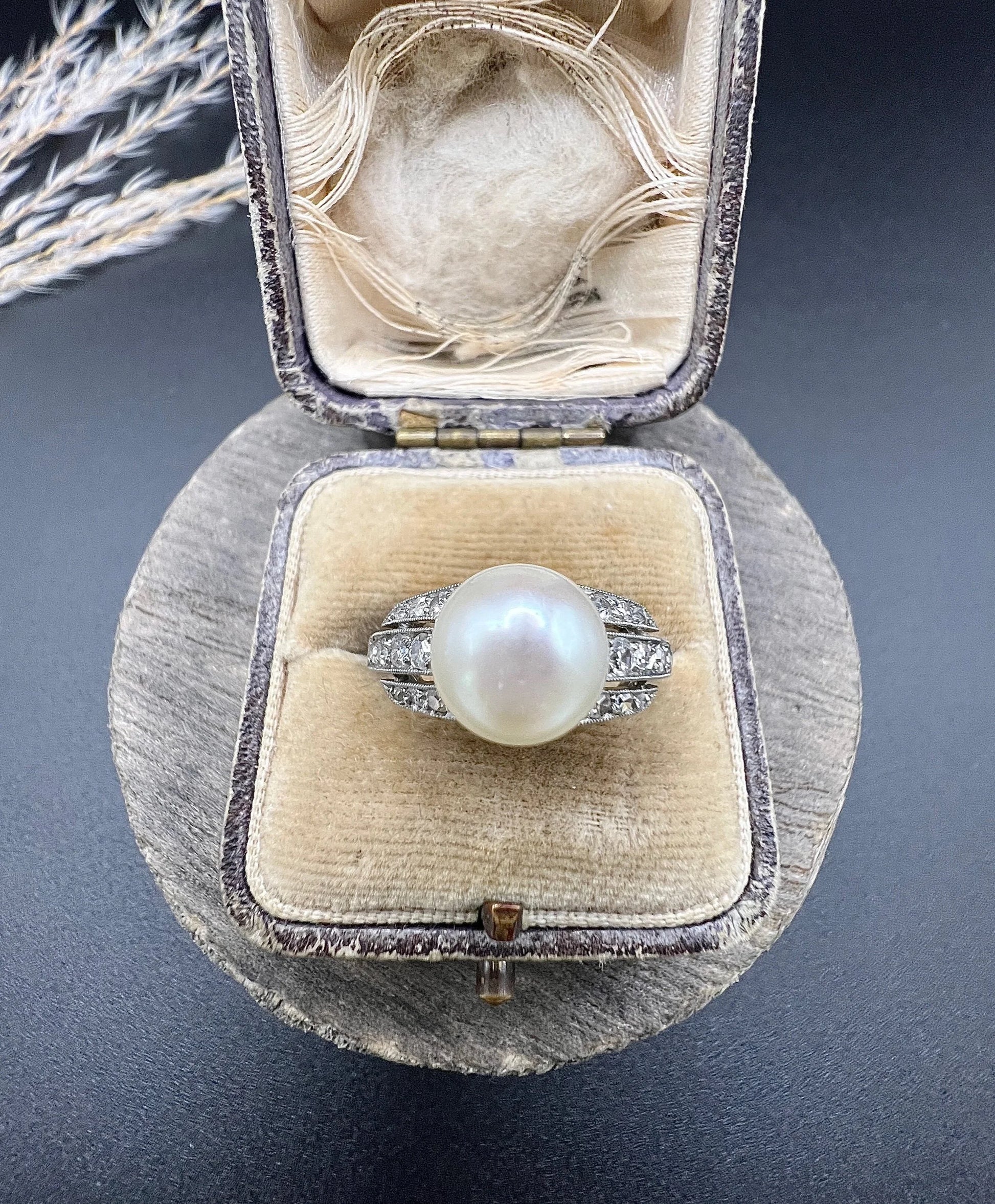 A pearl and diamond ring in platinum, in an antique ring box