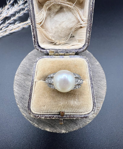 A pearl and diamond ring in platinum, in an antique ring box