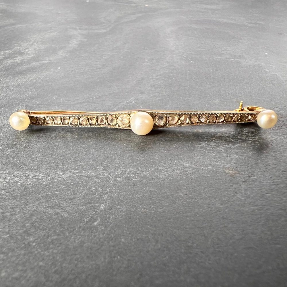 Antique Natural Pearl and Rose Cut Diamond Bar Brooch, set with three button-shape natural white pearls interspaced by 20 rose-cut and two old-cut diamonds in silver upon 18ct yellow gold