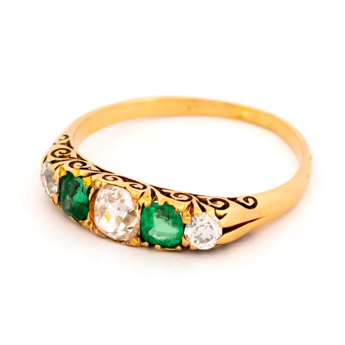 A five stone old cut emerald and diamond graduated ring in yellow gold