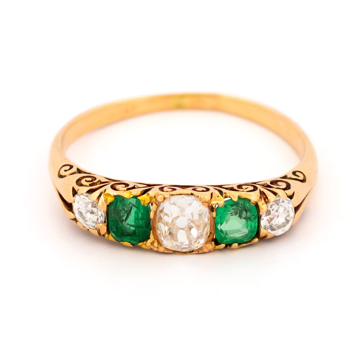 A five stone old cut emerald and diamond graduated ring in yellow gold