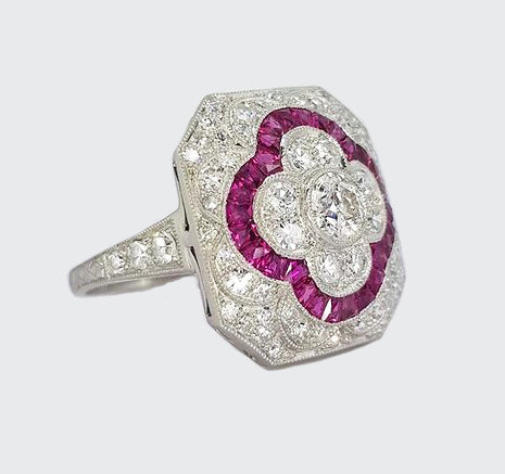 Ruby, Diamond and Platinum Panel Cluster Cocktail Ring; A diamond set panel ring, with central motif of calibre-cut rubies.