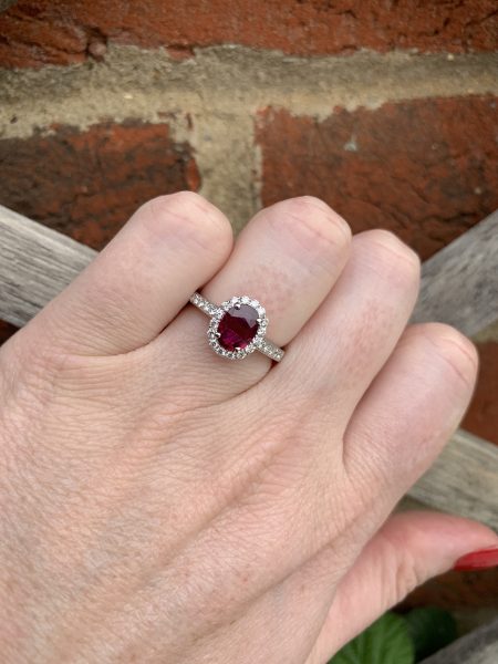 Burma Ruby and Diamond Cluster Ring; central 1.11ct oval faceted Burmese ruby with no indication of heat treatment set within a diamond halo, with diamond set shoulders, in 18ct white gold