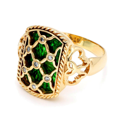 A yellow gold ring with green enamel and round diamonds set into a trellis design, against a white background