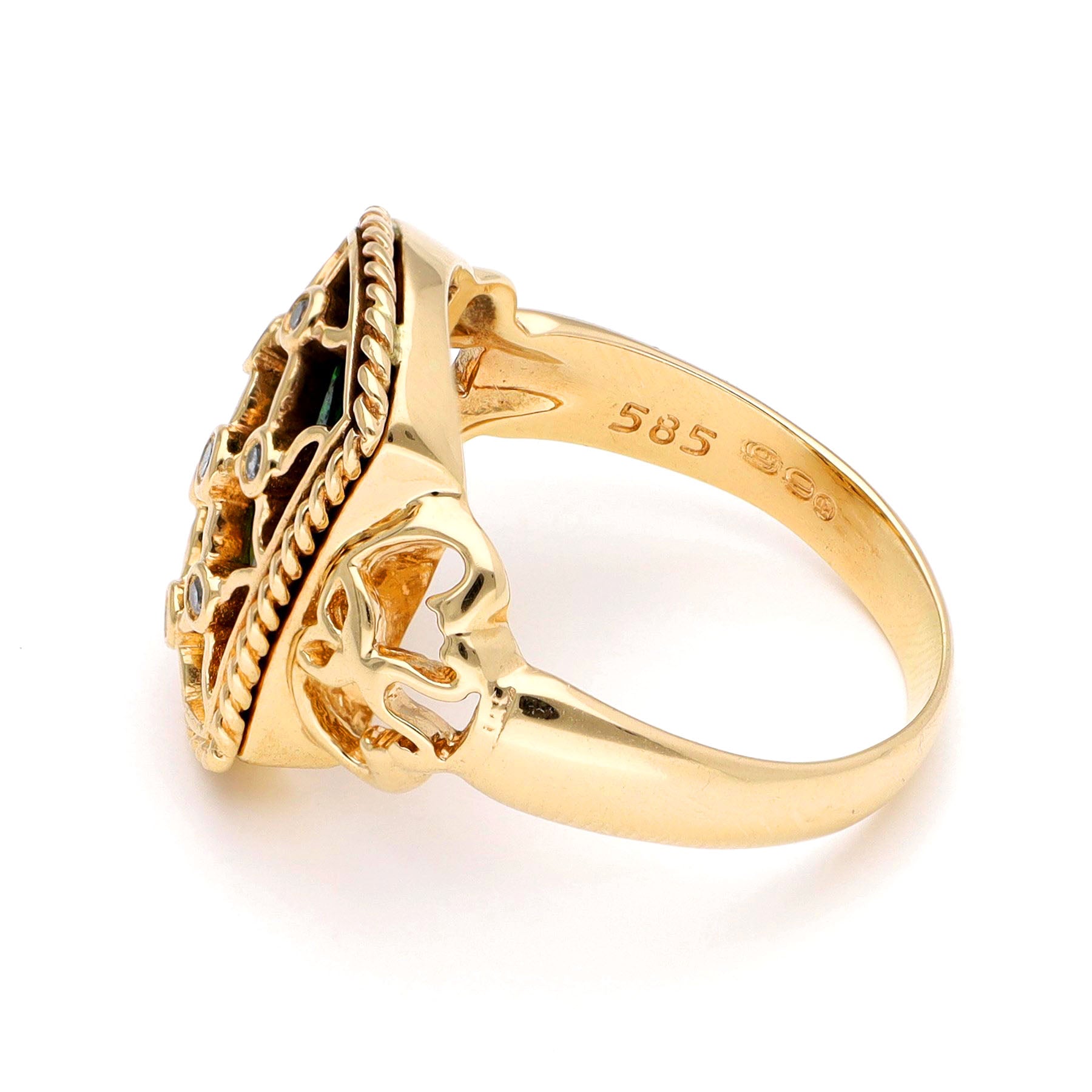 A yellow gold ring with green enamel and round diamonds set into a trellis design, against a white background