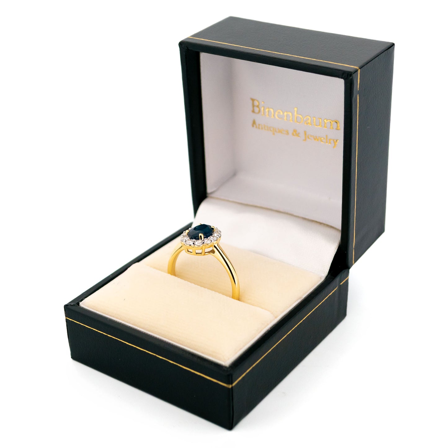 An oval sapphire and round diamond cluster ring in yellow and white gold, in a Binenbaum ring box
