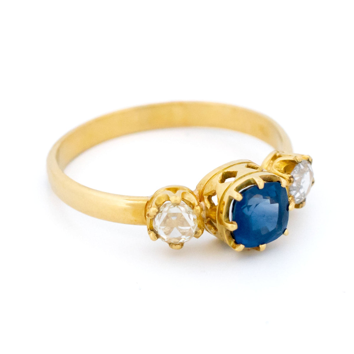 A sapphire and rose cut diamond three stone ring in yellow gold