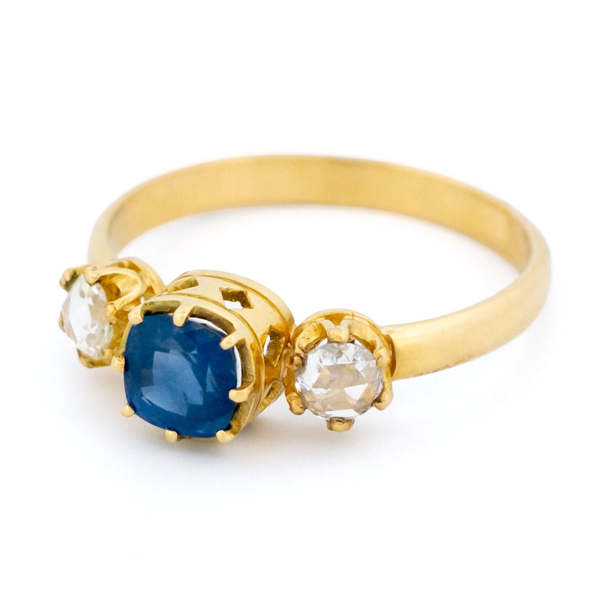 A sapphire and rose cut diamond three stone ring in yellow gold