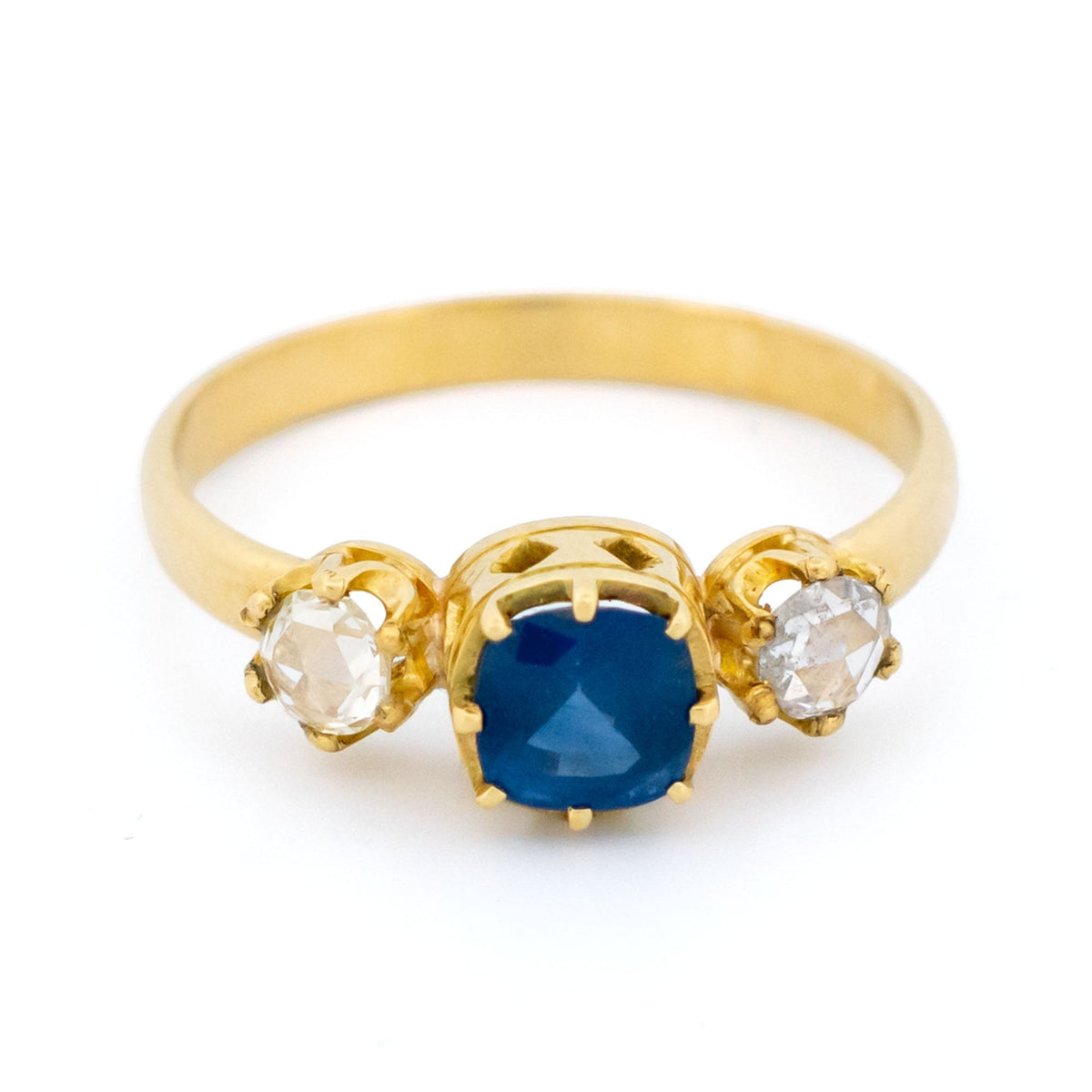 A sapphire and rose cut diamond three stone ring in yellow gold
