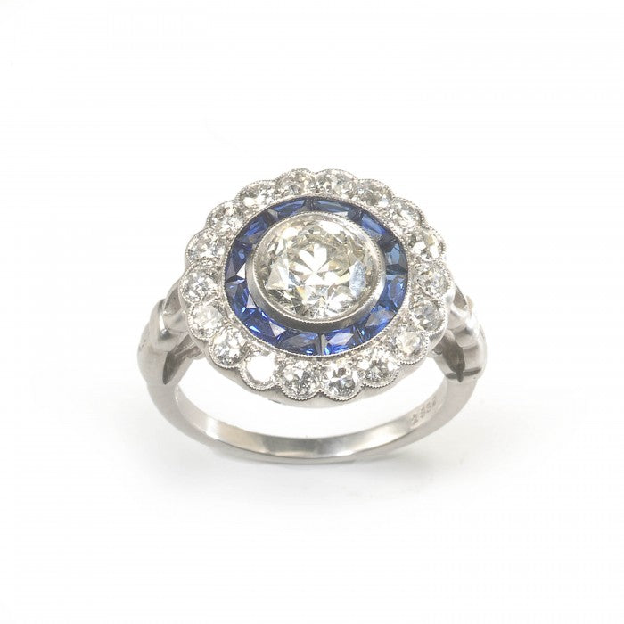 Art Deco Style Diamond and Sapphire Target Cluster Ring; 1.40ct round European old-cut diamond surrounded by twelve French-cut sapphires and an outer border of 0.93cts brilliant-cut diamonds, in platinum
