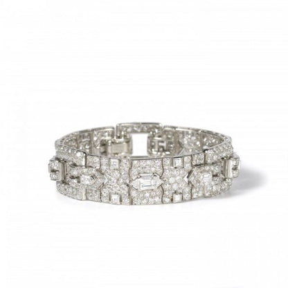 Vintage Cartier Diamond Bracelet; comprised of three panels, each set with a central trap-cut diamond flanked by triangular and fancy-cut diamonds, accented with transitional brilliant-cut and single-cut diamond set surrounds, 18.70 carat total. Mounted in platinum. Circa 1930
