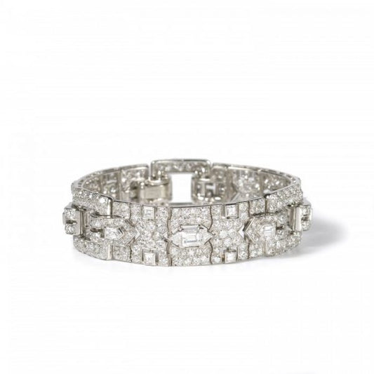 Vintage Cartier Diamond Bracelet; comprised of three panels, each set with a central trap-cut diamond flanked by triangular and fancy-cut diamonds, accented with transitional brilliant-cut and single-cut diamond set surrounds, 18.70 carat total. Mounted in platinum. Circa 1930
