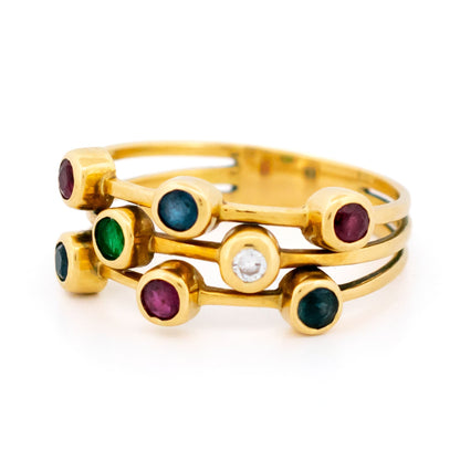 A multi-band ring in yellow gold set with round sapphires, rubies, an emerald and a diamond