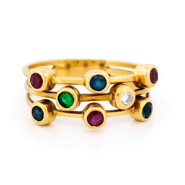 A multi-band ring in yellow gold set with round sapphires, rubies, an emerald and a diamond