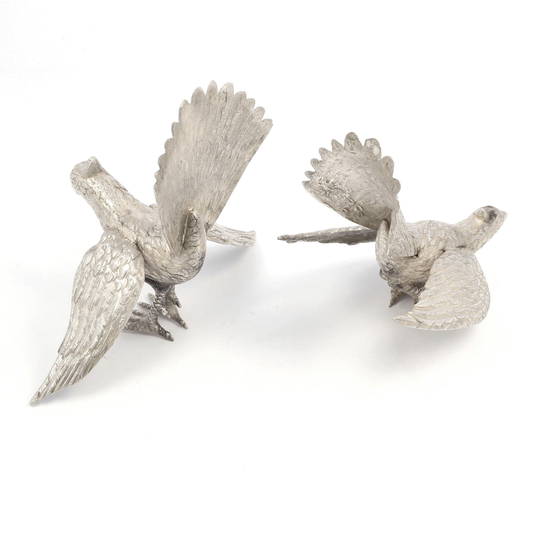 Two silver bird sculptures on a white background